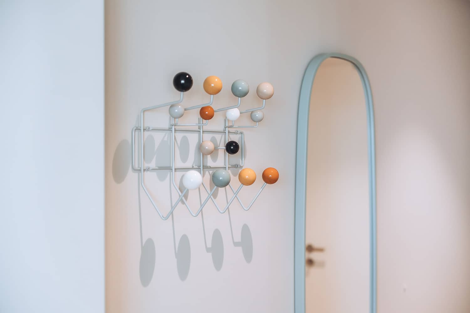 An einer Wand h&auml;ngt eine Garderobe mit bunten runden Haken